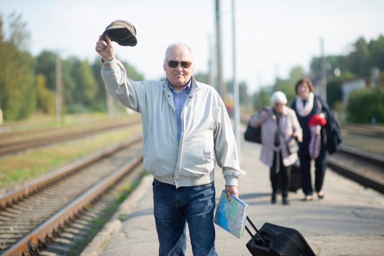 Пенсионер ждет поезд РЖД на перроне