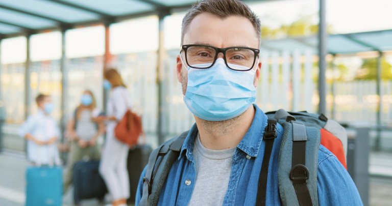 Мужчина в медицинской маске на перроне ждет поезд РЖД