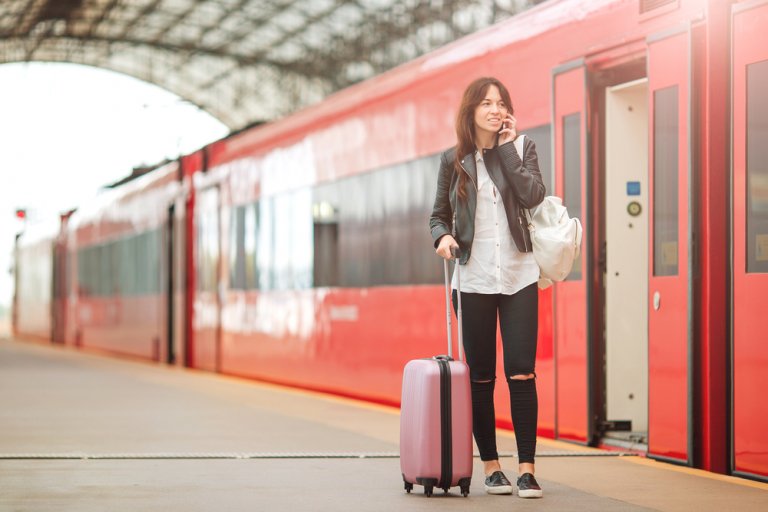 Женщина с багажом на перроне у вагона СВ поезда РЖД